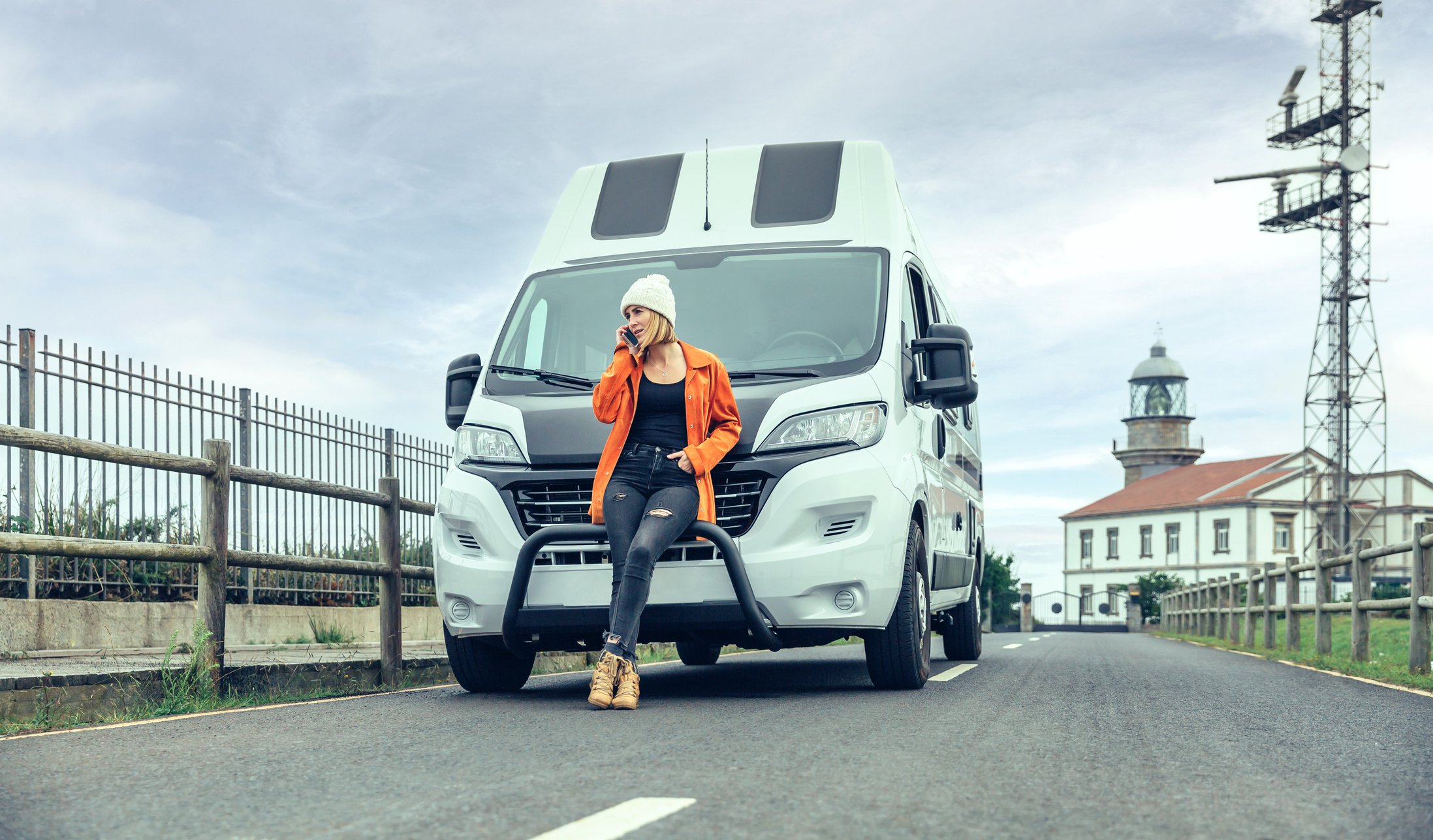 Woman Leaning on Camper Van on the Road