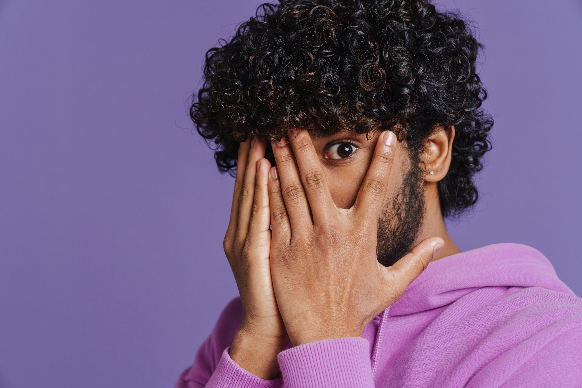 Portrait of Young Indian Curly Scared Man Covering His Face